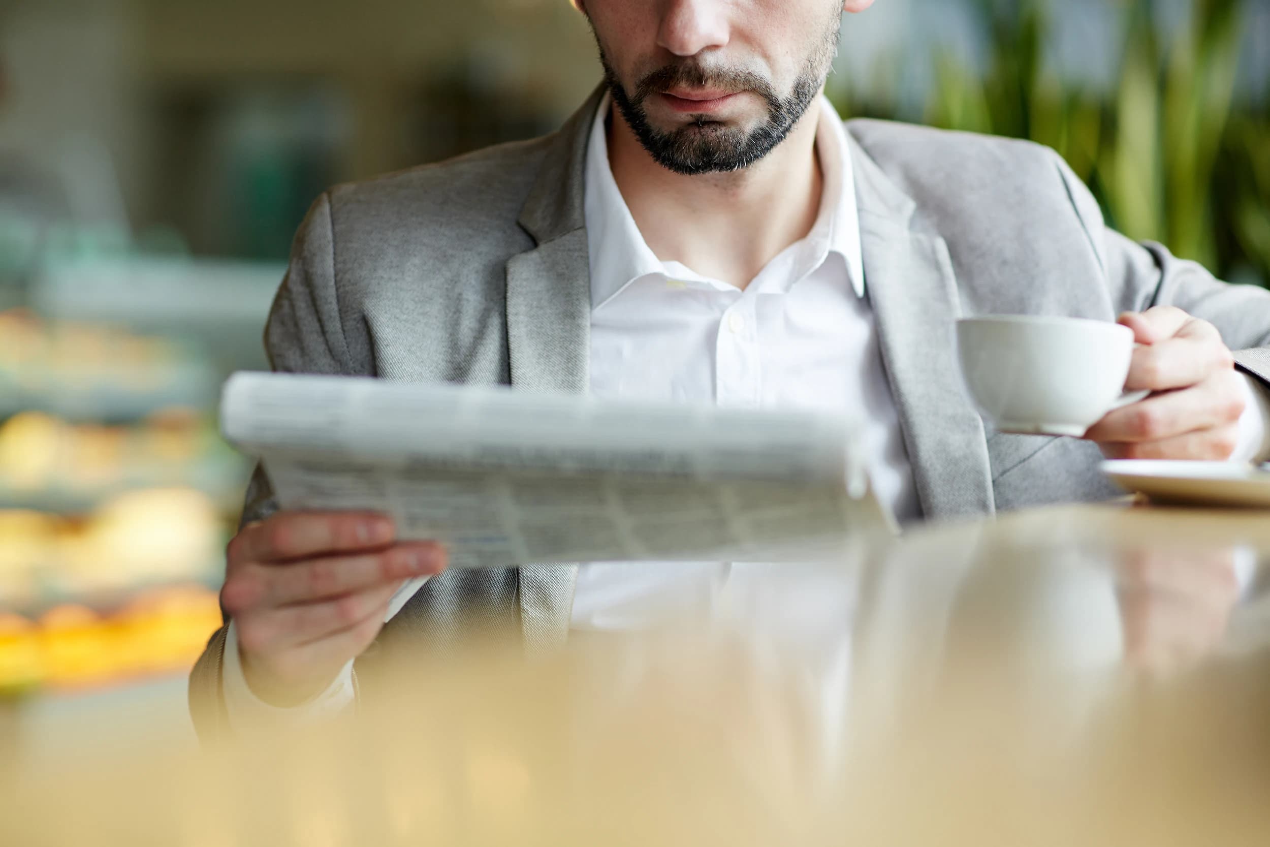 Tasse Tee neben einer aufgeschlagenen Zeitung